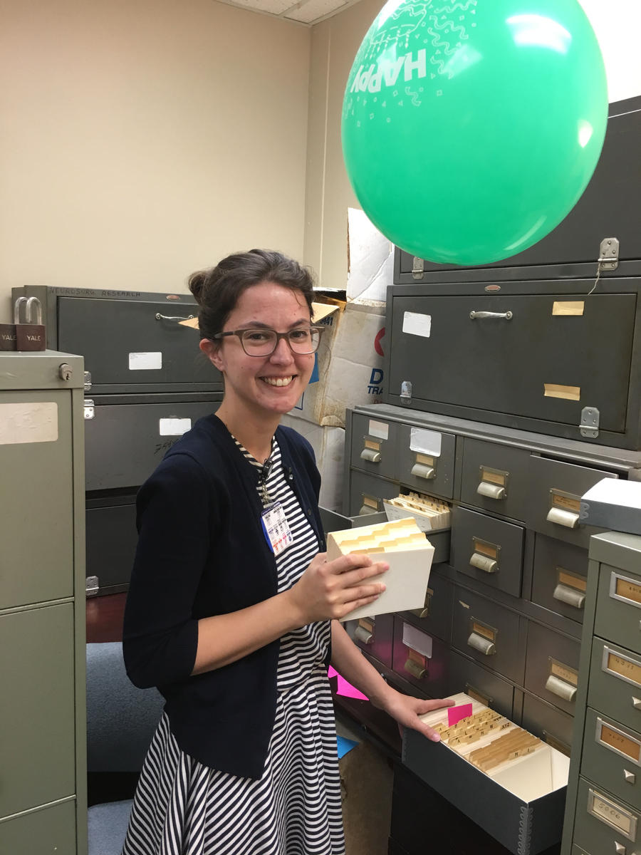 Archives Intern Kahlee Leingang packing up Department of Neurosurgery materials while dodging a balloon.